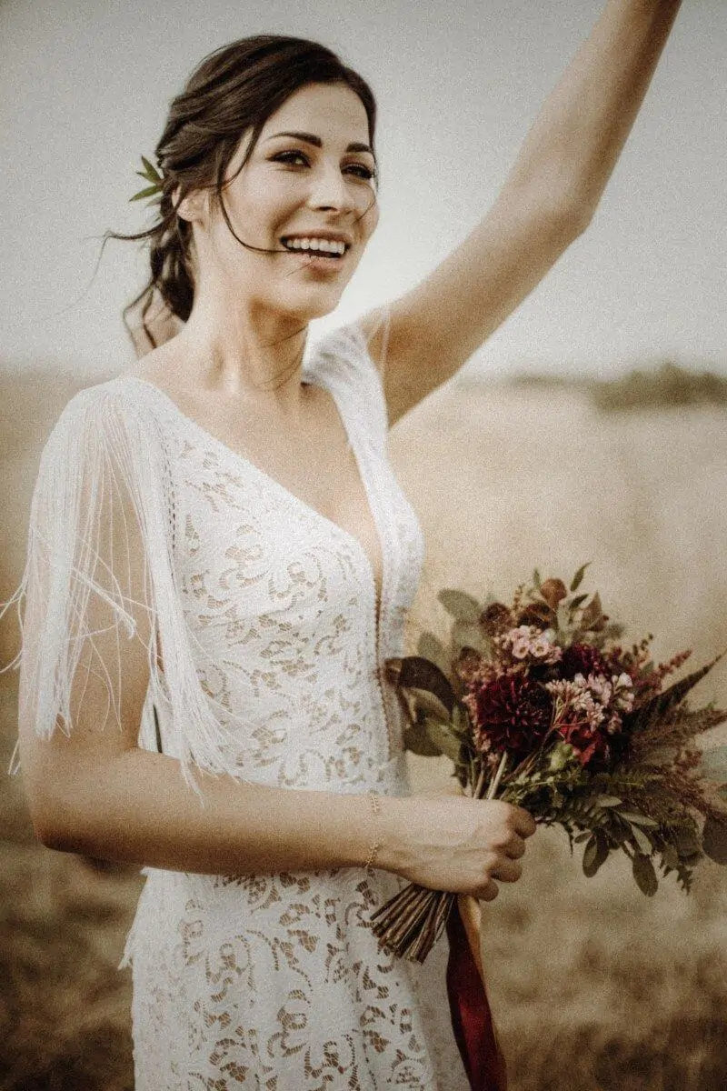 Suknia ślubna w stylu boho Santorini 1 z dodatkowymi frędzlami na ramionach i plecach.
