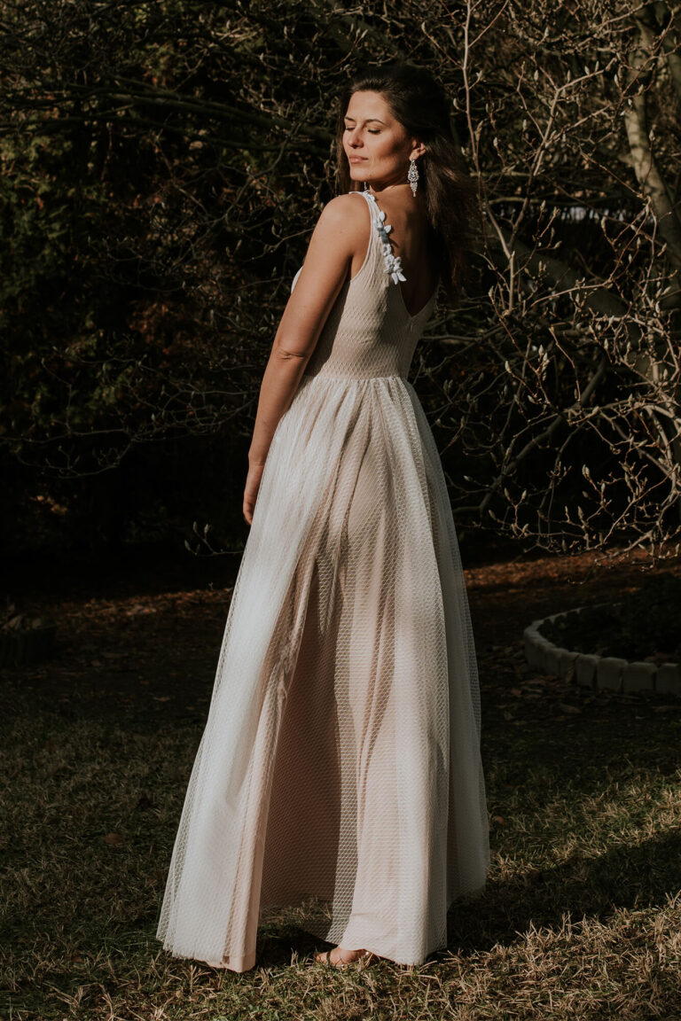 Suknia z odkrytymi plecami i długim trenem z tiulu.