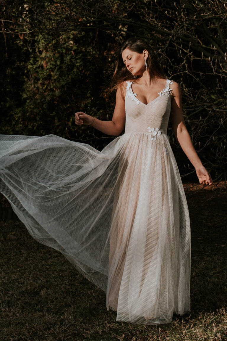 Suknia z tiulu z długim rozkloszowanym dołem i koronkowym dekoltem w kształcie litery V.