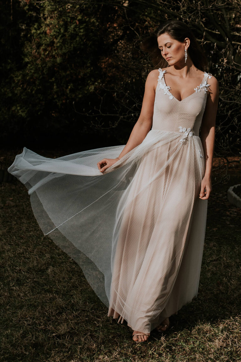 Suknia z długim tiulowym trenem i dekoltem w kształcie litery V.