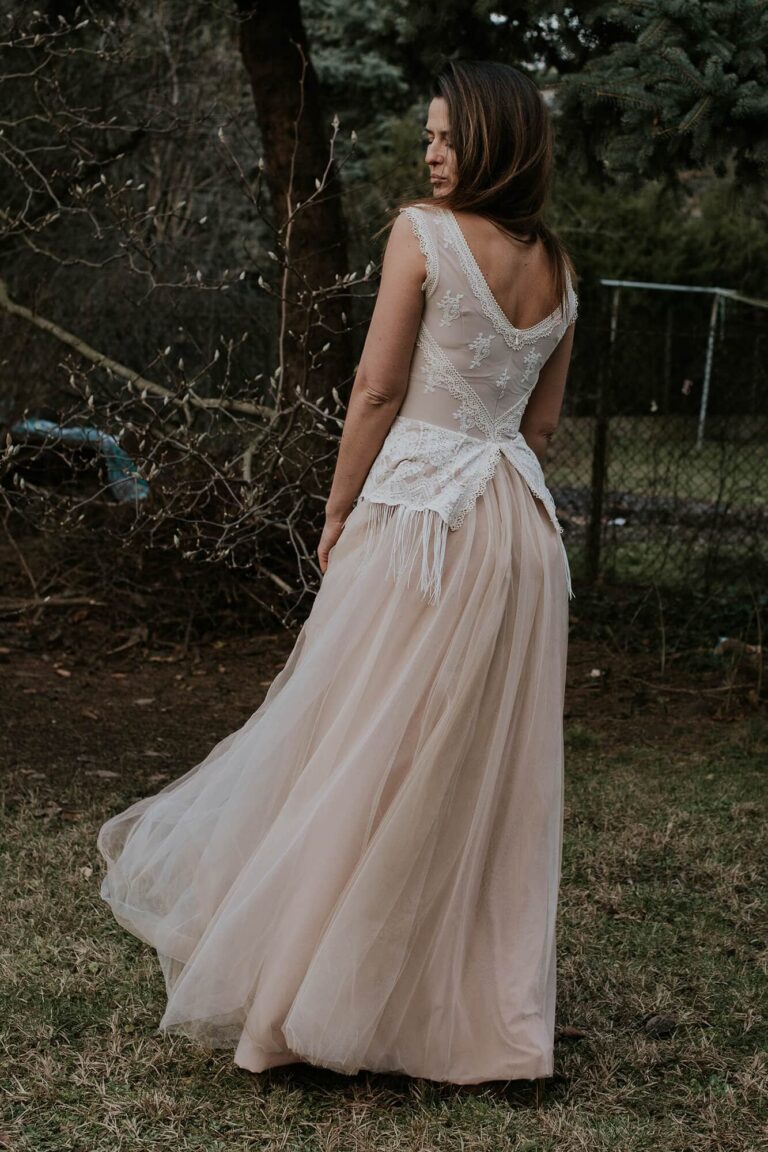 Suknia z odkrytymi plecami i długim trenem widziana z tyłu.