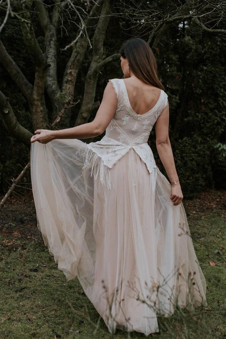 Suknia ślubna z odkrytymi plecami i długim tiulowym trenem.