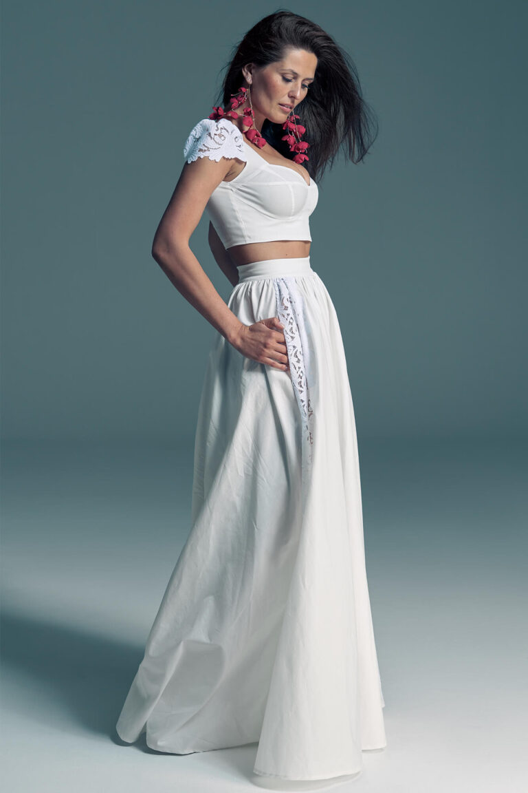 Suknia ślubna z białą koronkową bluzką i długą, zwiewną spódnicą, ozdobiona delikatnym haftem.