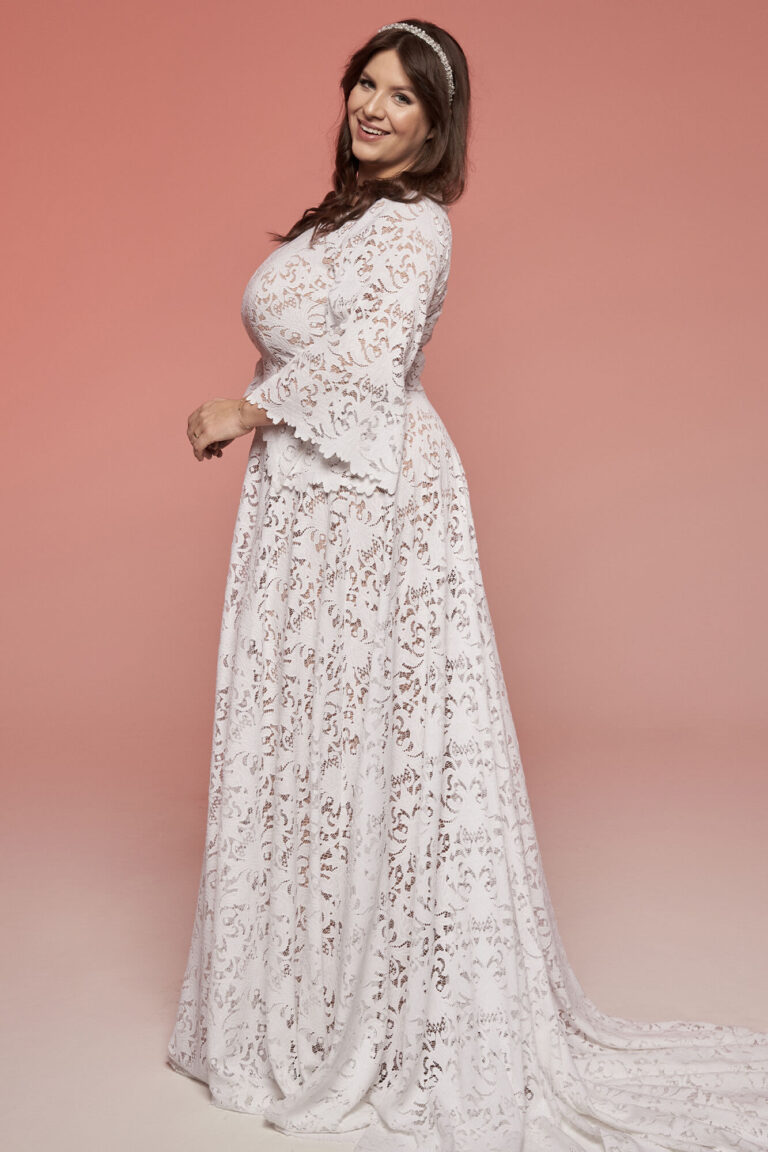 Suknia ślubna z długimi rękawami, koronkowym wzorem i długim trenem.