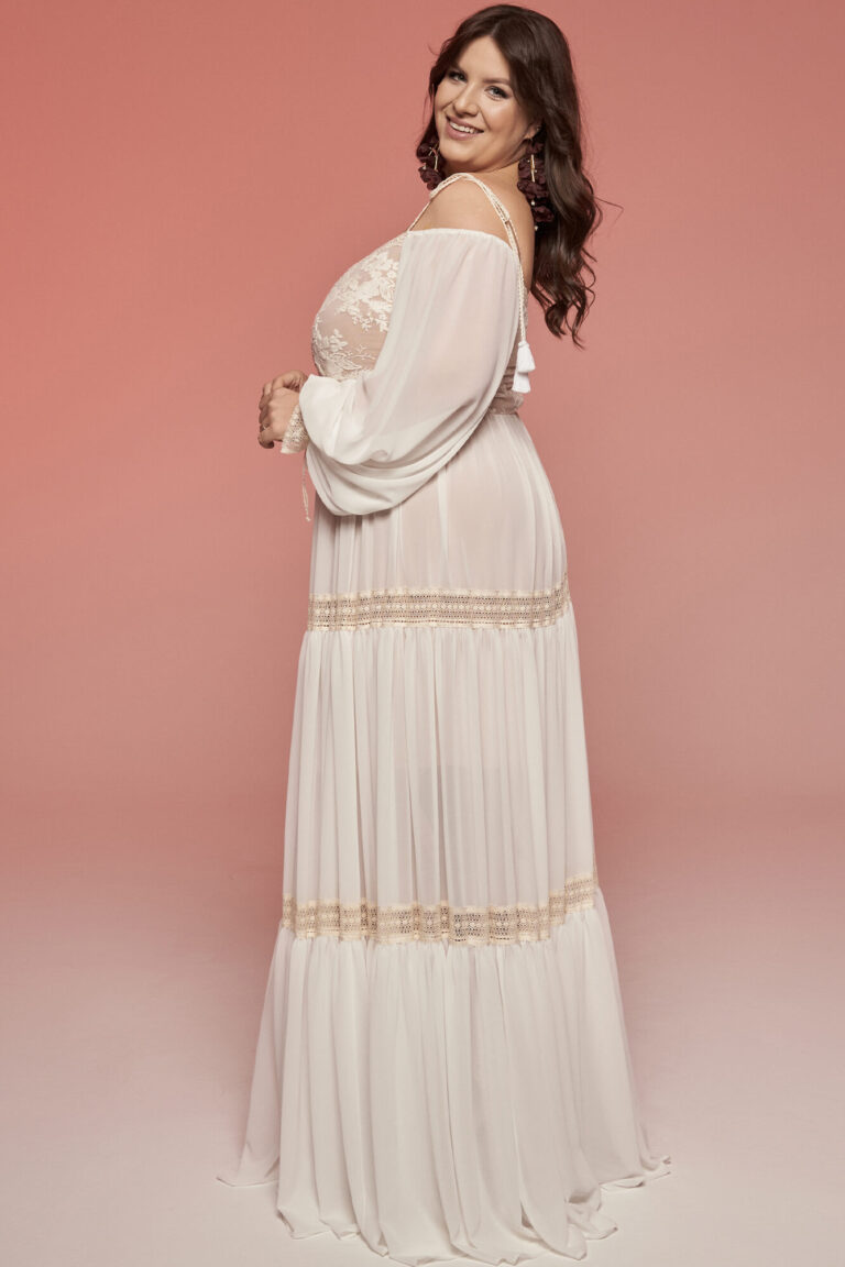 Suknia z długimi rękawami i rozkloszowanym dołem w kolorze białym.