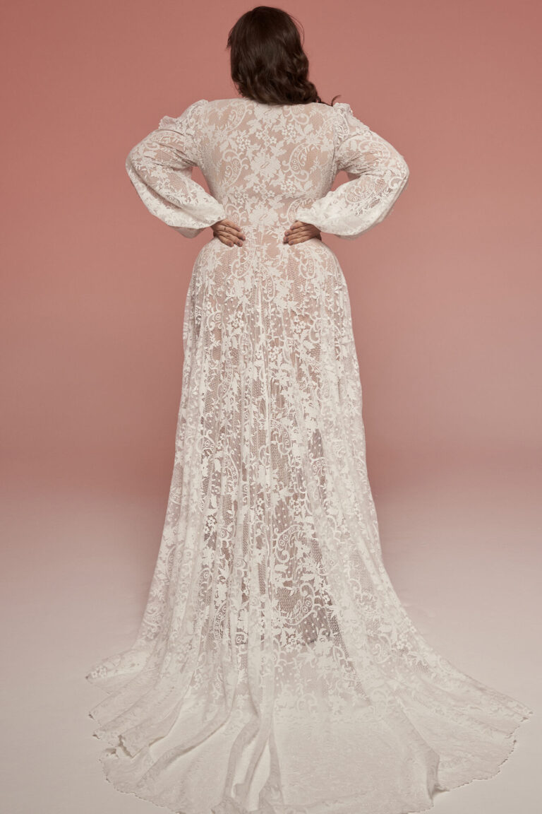 Suknia ślubna z długimi rękawami, koronkowym wykończeniem i długim trenem widziana z tyłu.