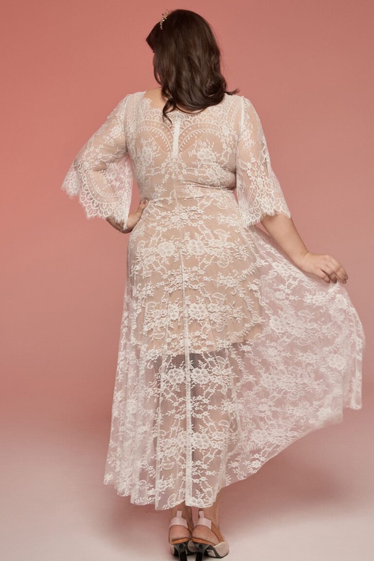 Suknia z koronkowymi rękawami i długim tyłem widziana z tyłu.