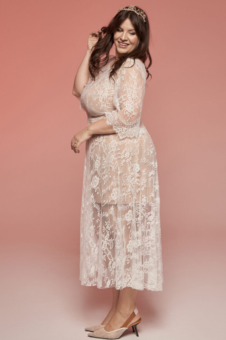 Suknia z długimi rękawami i koronkowym wykończeniem w jasnym kolorze.