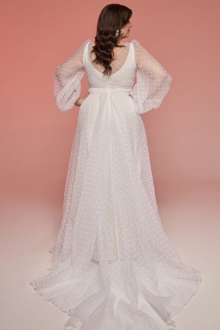 Suknia ślubna z długimi rękawami i odkrytymi plecami oraz długim trenem.