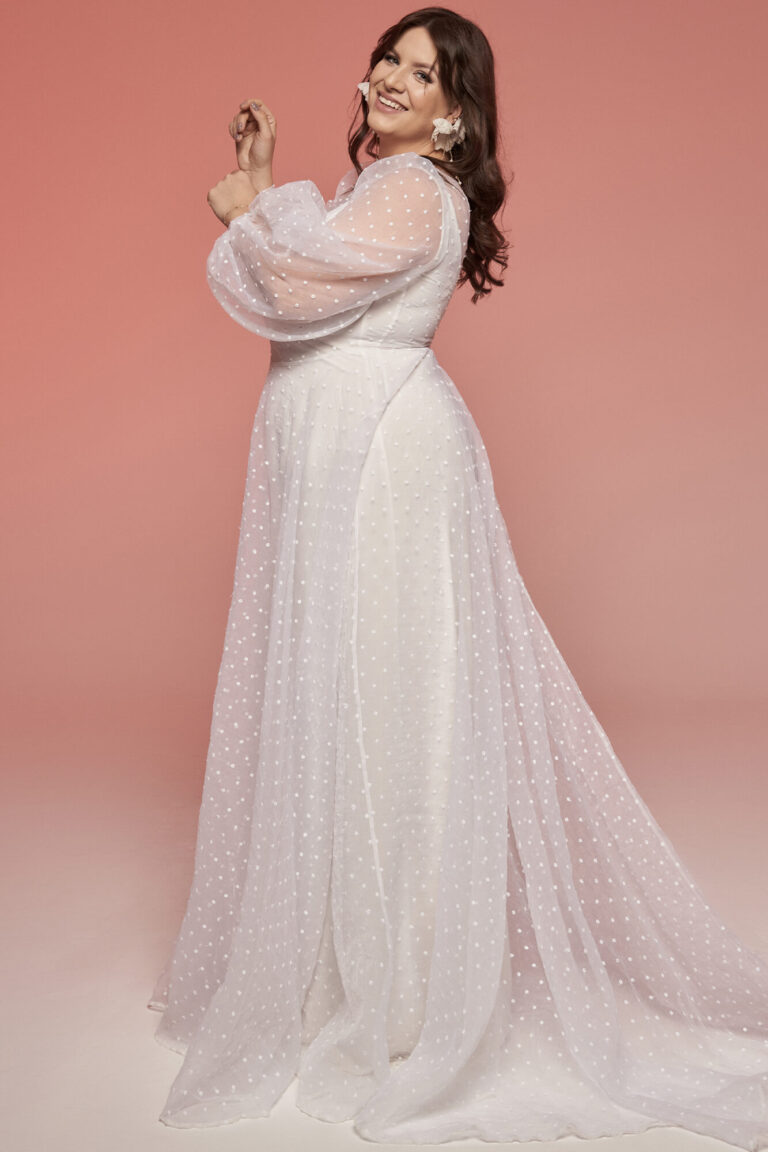 Suknia z długimi rękawami i trenem z tiulu, widoczna z boku.