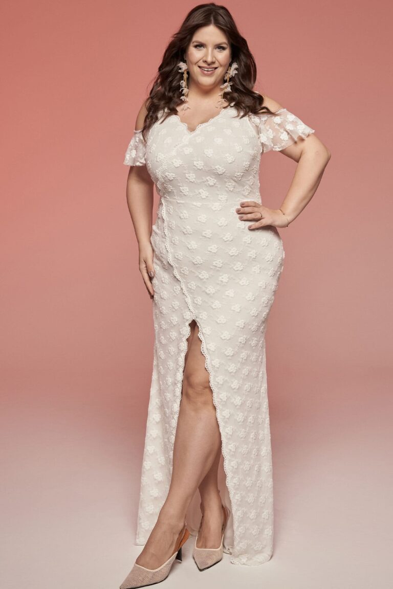 Suknia ślubna z dekoltem w serek, krótkimi rękawami i rozcięciem na udzie.