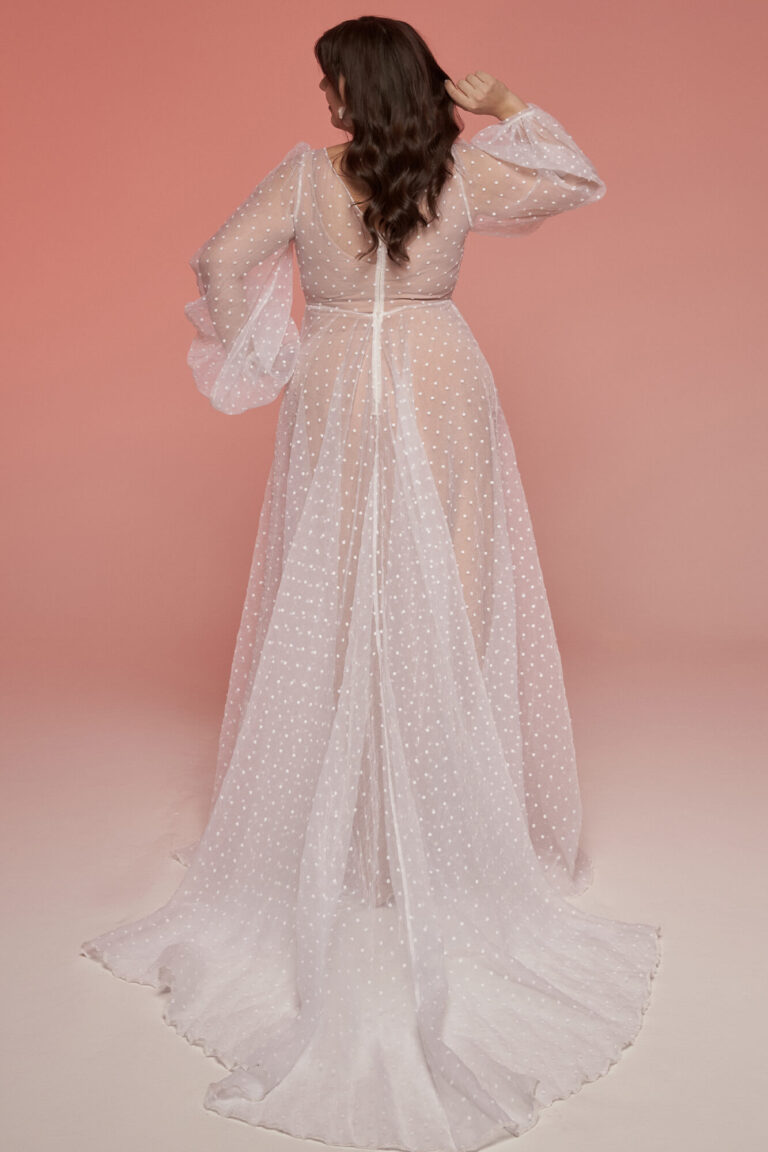 Suknia ślubna z długimi rękawami i transparentnym trenem widziana z tyłu.