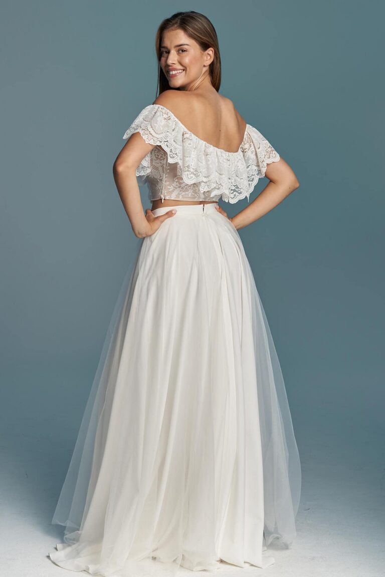 Suknia ślubna z odkrytymi plecami, tiulowym dołem i koronkowymi rękawami.