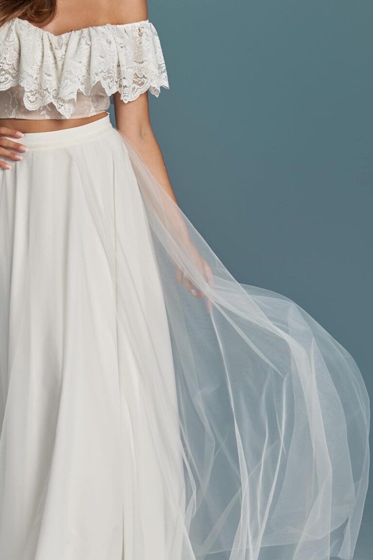 Suknia z odkrytymi ramionami i długim tiulowym dołem.