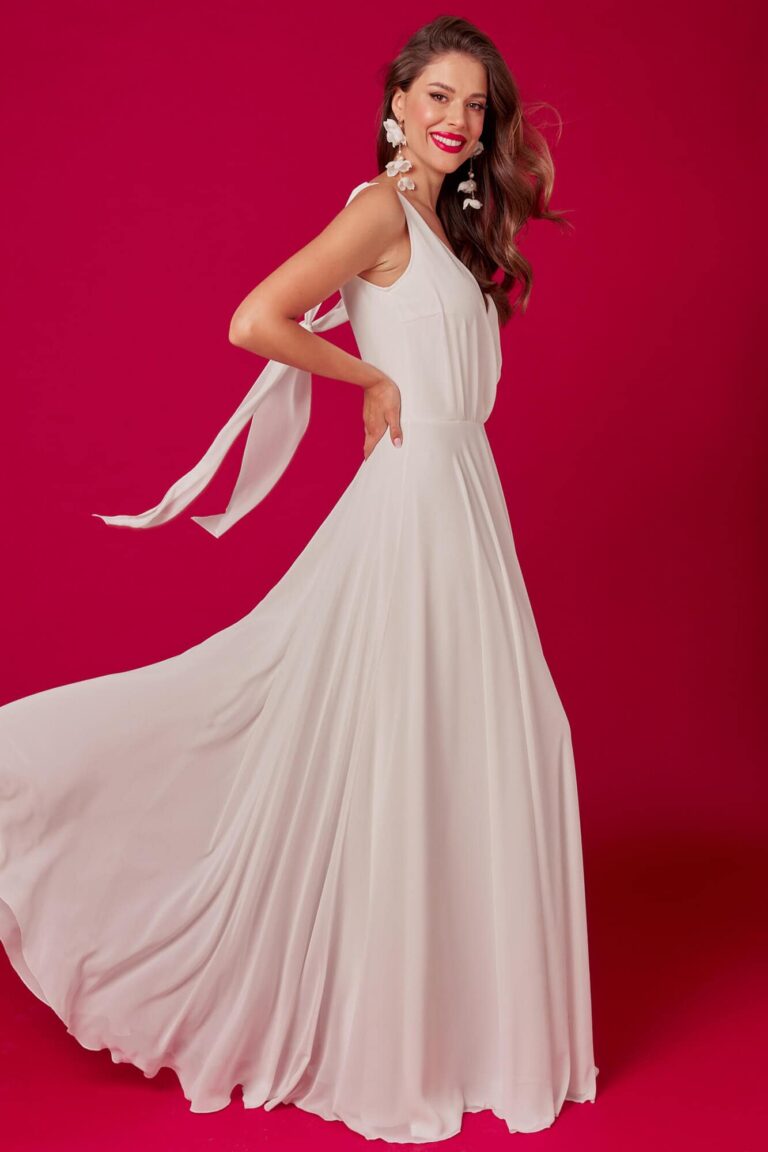 Suknia z długimi rękawami i falbanami w kolorze jasnoróżowym.