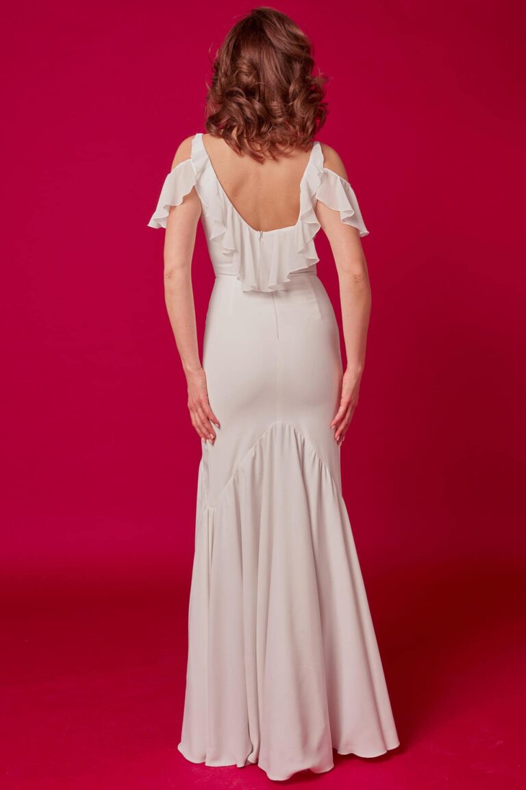 Suknia z odkrytymi plecami, długimi rękawami i rozkloszowanym dołem.