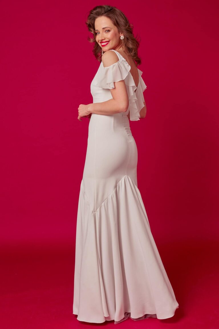 Suknia z odkrytymi plecami i falbanami na rękawach w jasnym kolorze.