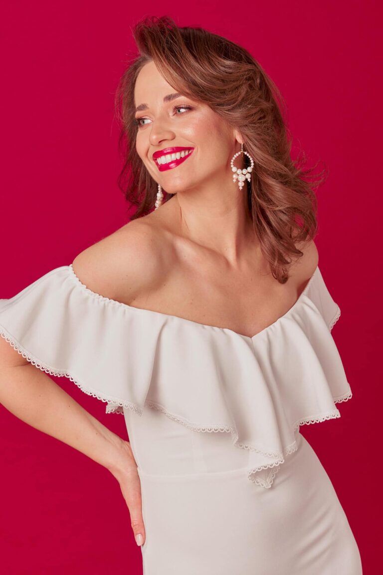 Suknia z odkrytymi ramionami i falbaną u góry.