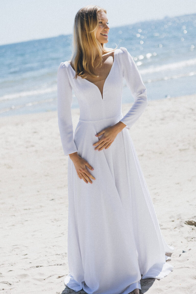 Suknia z długimi rękawami, dekoltem w serek i lekko rozkloszowanym dołem.