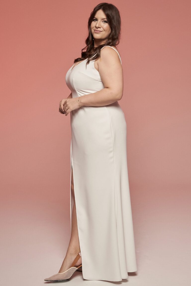 Suknia z odkrytymi ramionami i rozcięciem z przodu.