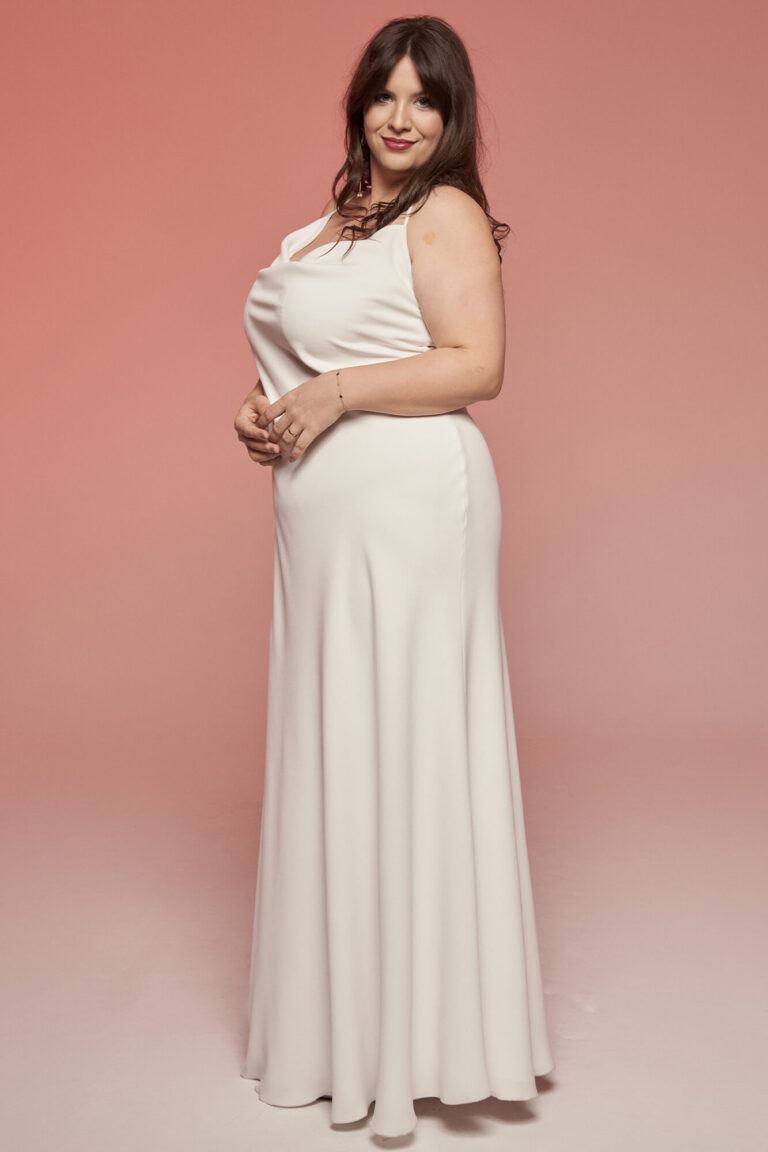 Suknia z odkrytymi ramionami i rozkloszowanym dołem w kolorze białym.