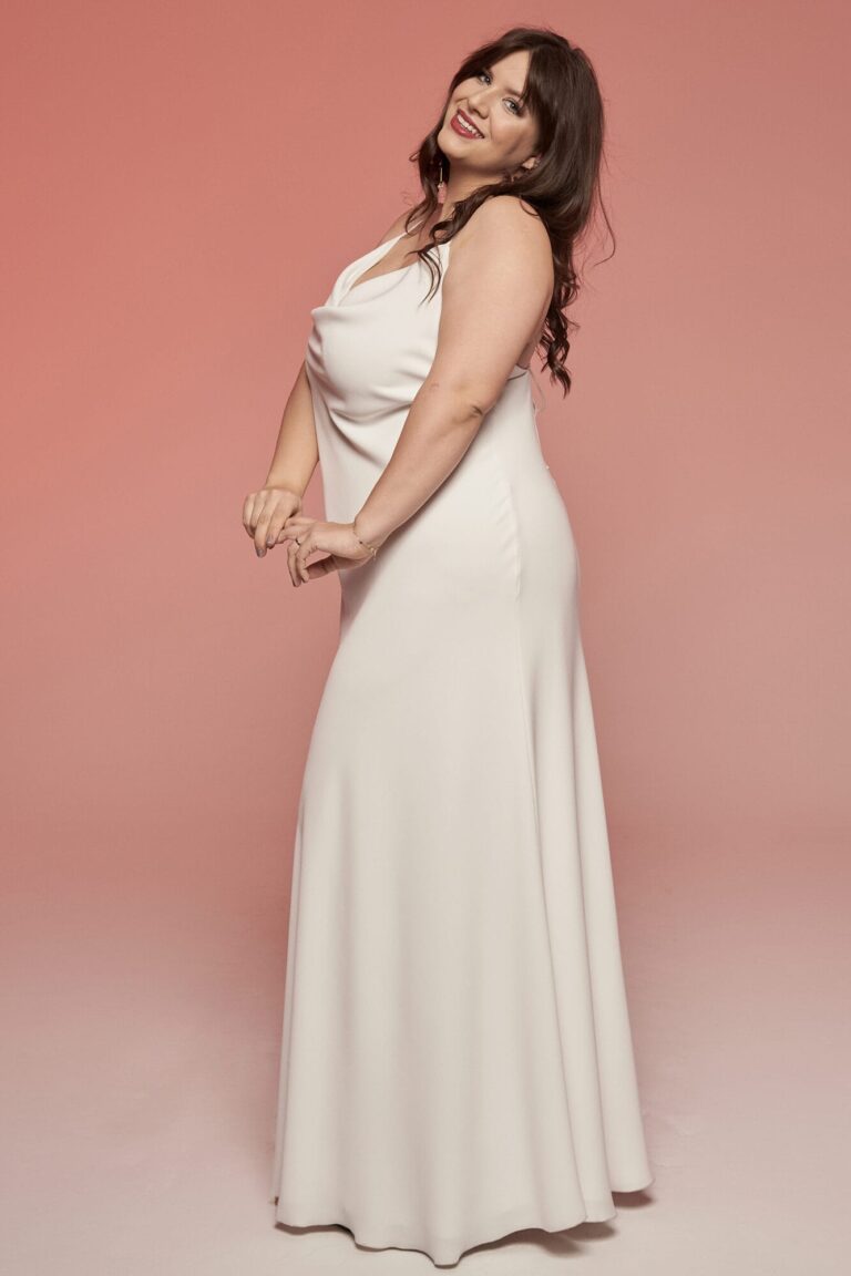 Suknia z odkrytymi ramionami i długim dołem w kolorze białym.