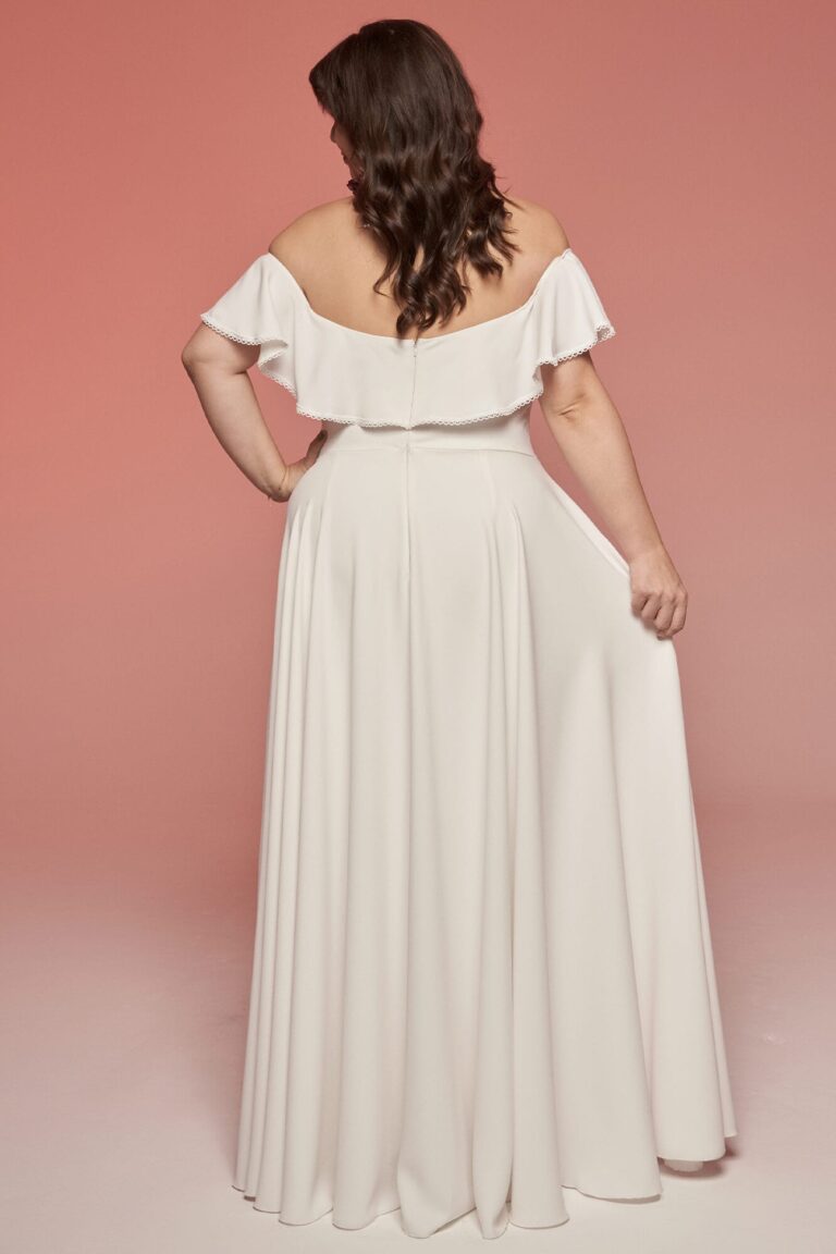 Suknia z odkrytymi plecami, długimi rękawami i rozkloszowanym krojem.