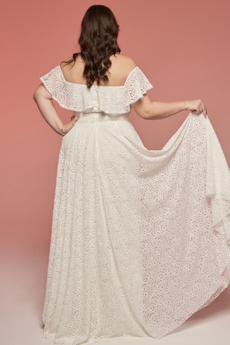 Suknia z odkrytymi plecami, długimi rękawami i trenem z koronkowego materiału.