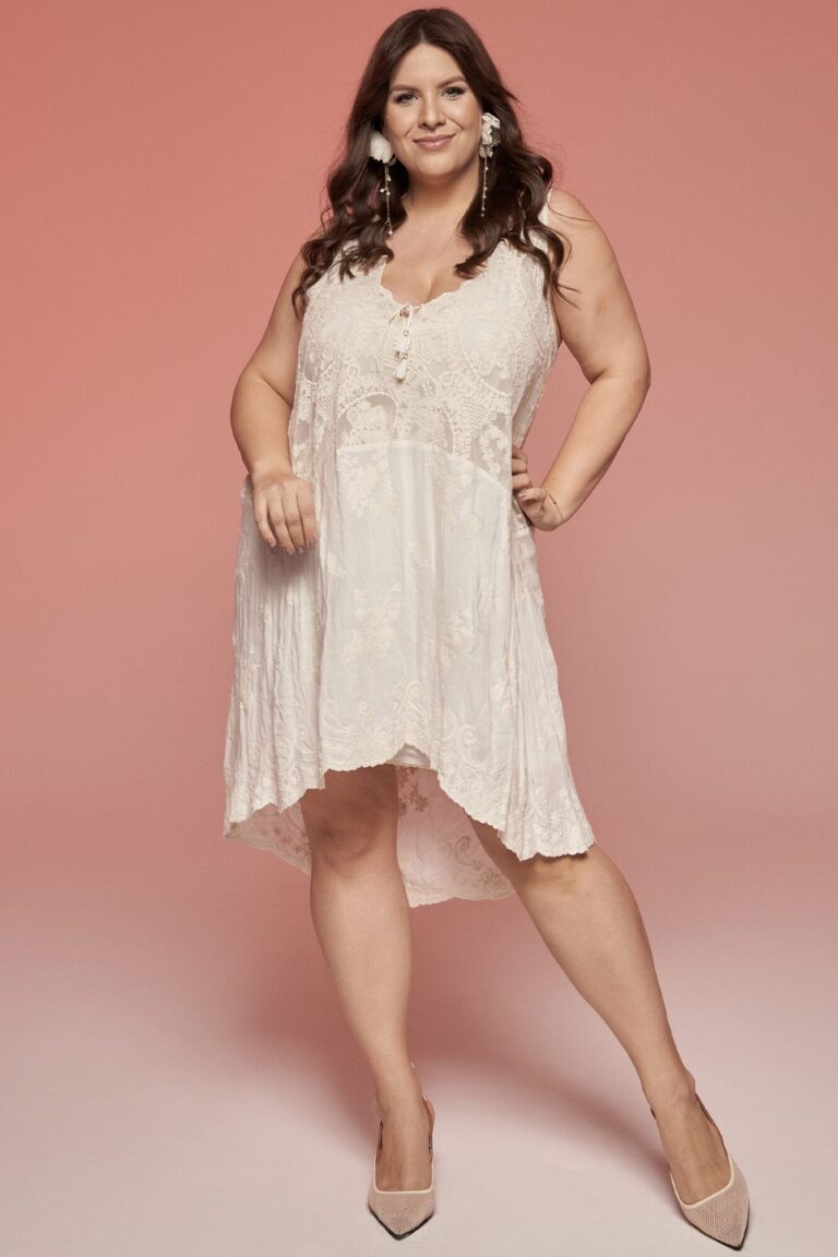 Suknia z odkrytymi ramionami, koronkowymi detalami i asymetrycznym dołem.