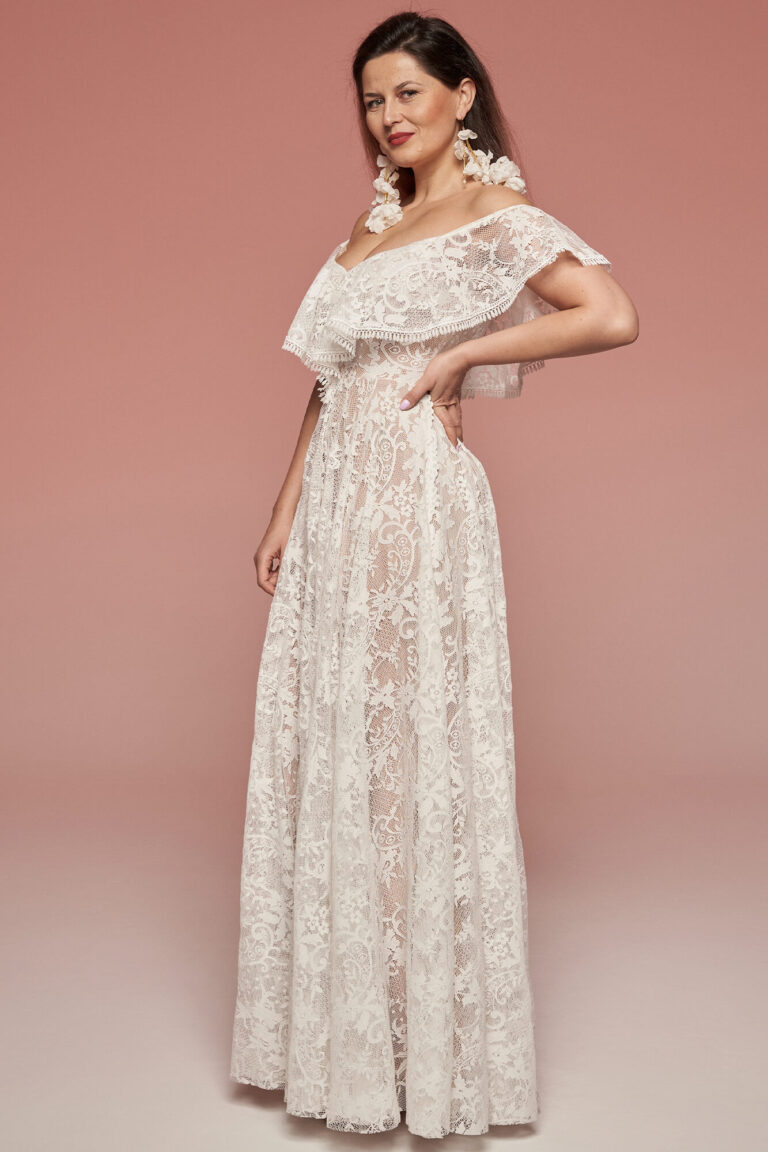 Suknia z koronkowymi rękawami i rozkloszowanym dołem, w kolorze białym.