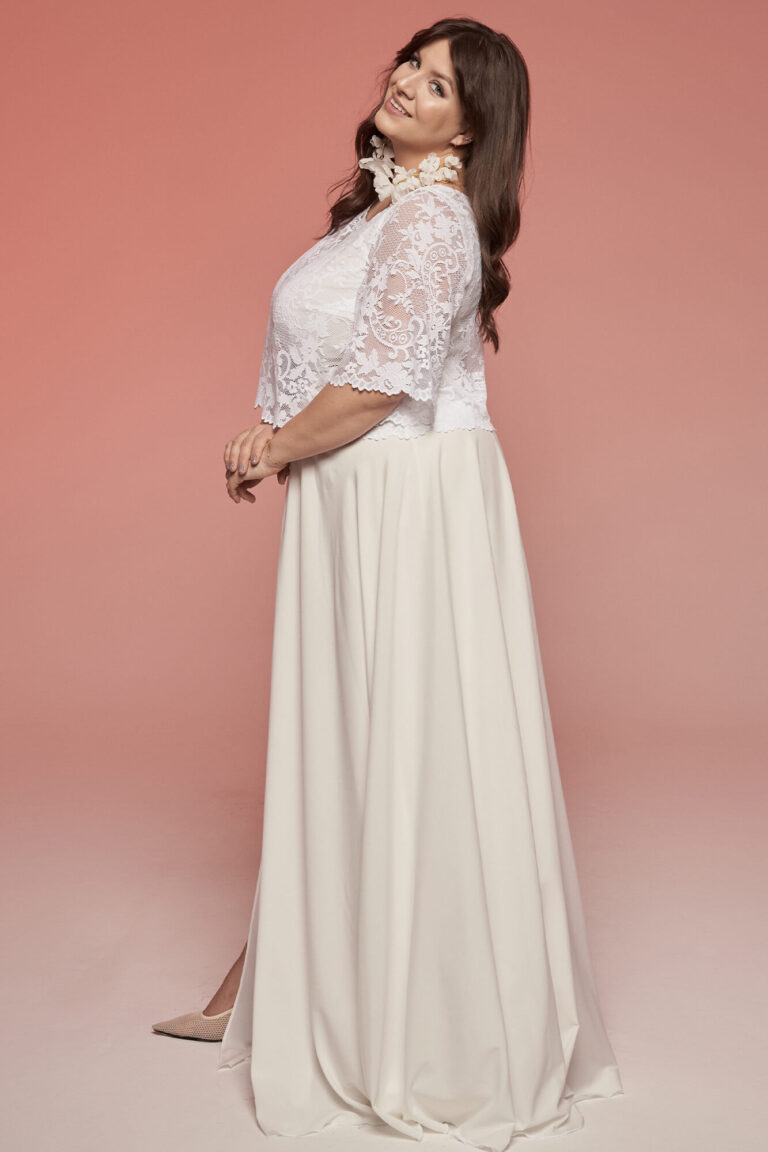 Suknia ślubna z długimi koronkowymi rękawami i rozkloszowanym dołem.