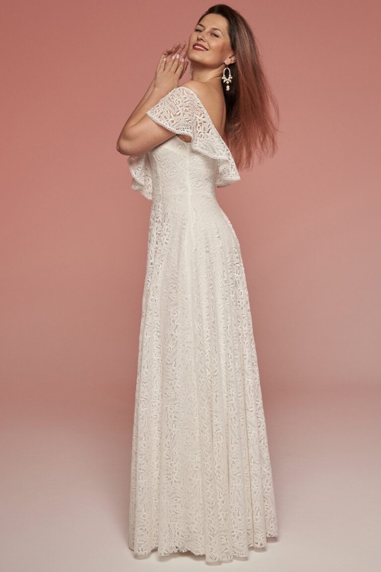 Suknia z odkrytymi ramionami i długim, prostym krojem z koronkowego materiału.