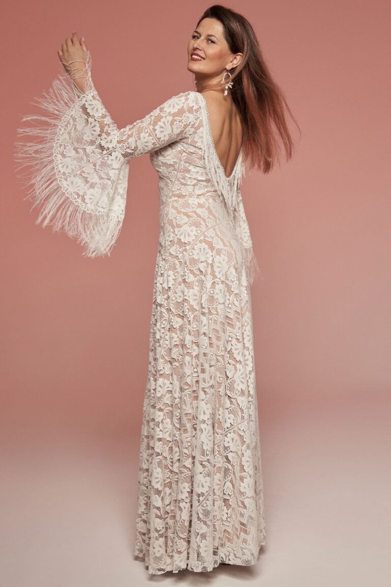 Suknia z długimi rękawami i odkrytymi plecami, wykonana z koronki.