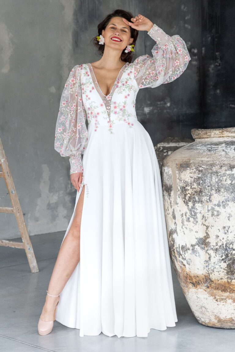 Suknia z długimi koronkowymi rękawami i rozcięciem z przodu.