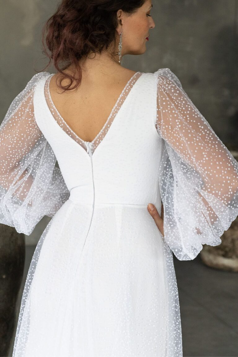 Suknia z odkrytymi plecami i długimi rękawami z tiulu.