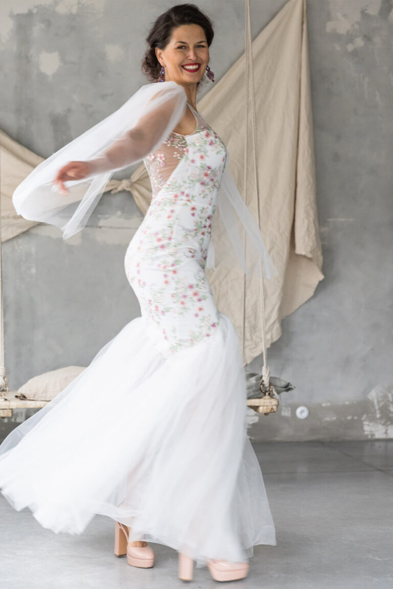 Suknia ślubna z koronkowym gorsetem i długim tiulowym trenem.