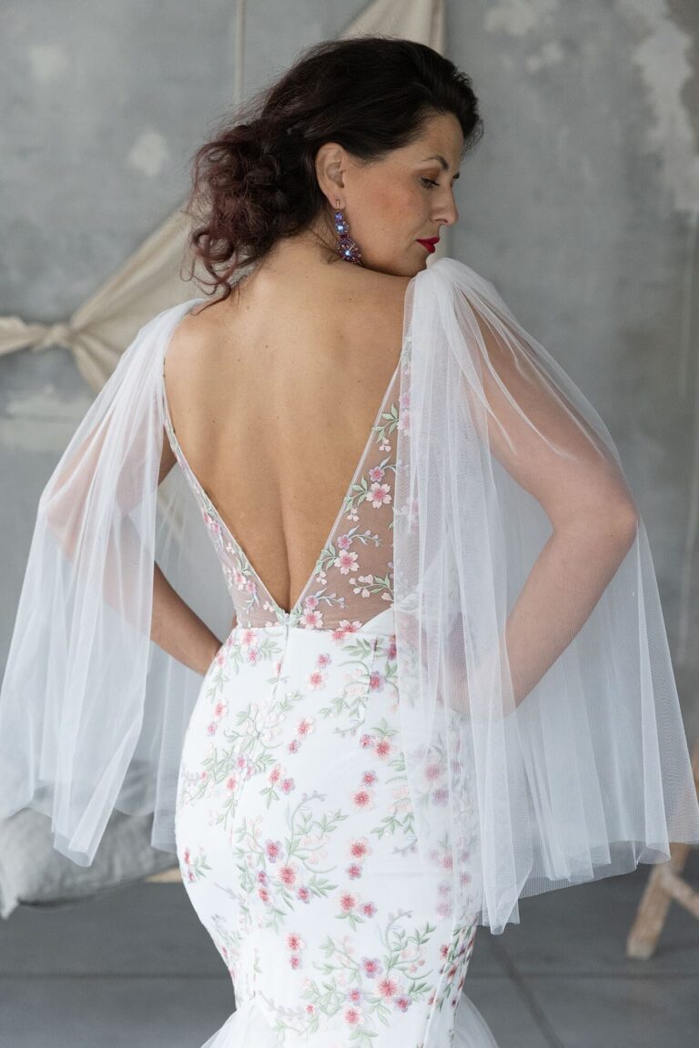 Suknia z odkrytymi plecami, koronkowym dołem i tiulowymi rękawami.