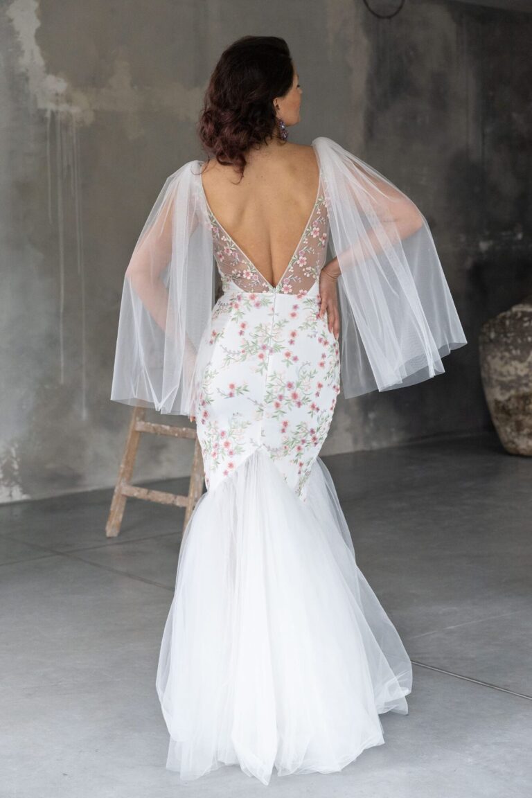 Suknia ślubna z odkrytymi plecami, długimi rękawami i trenem z tiulu.