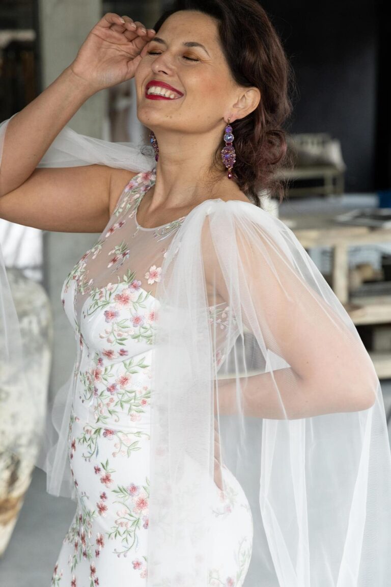 Suknia z koronkowymi detalami i przezroczystymi rękawami.