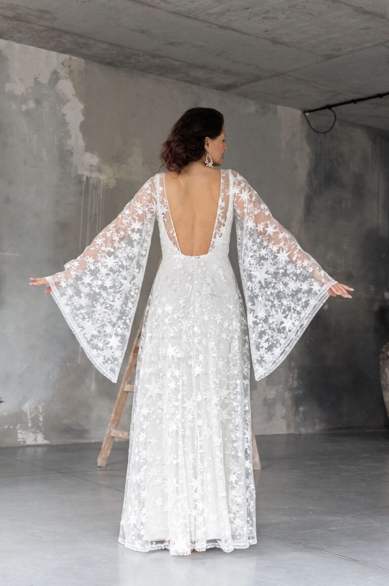 Suknia ślubna z odkrytymi plecami i długimi rękawami z koronki.