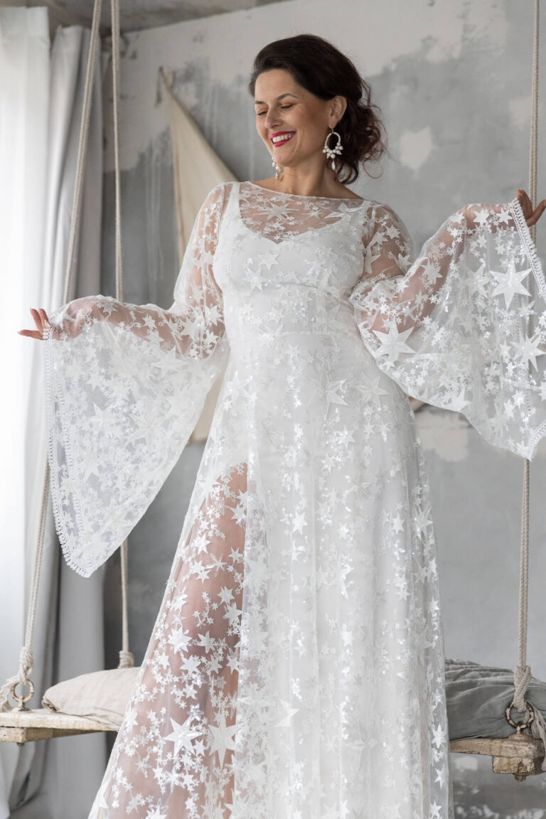 Suknia ślubna z długimi koronkowymi rękawami i delikatnym dekoltem.