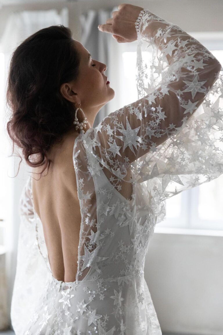 Suknia ślubna z długimi koronkowymi rękawami i odkrytymi plecami