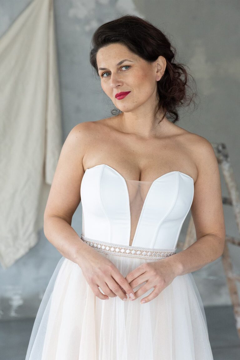 Suknia ślubna z dekoltem w kształcie serca i tiulowym dołem.