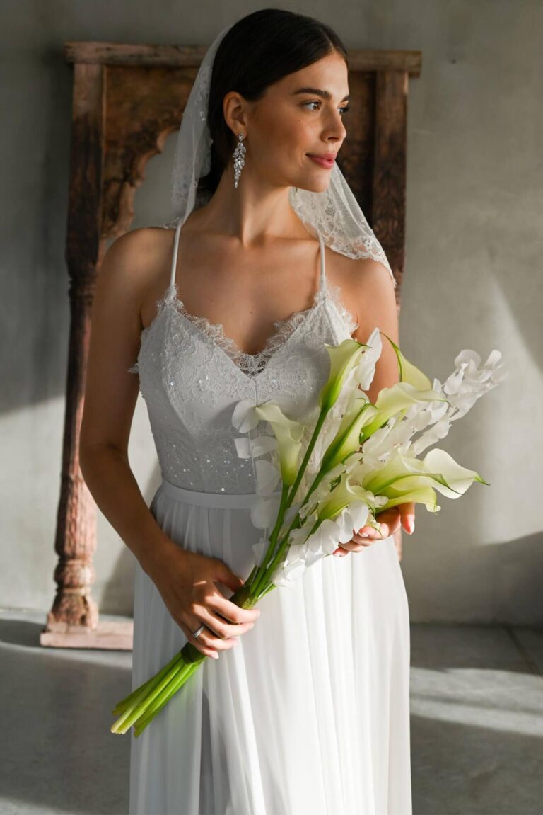 Suknia z koronkowym dekoltem i długimi plecami, z odkrytymi ramionami.