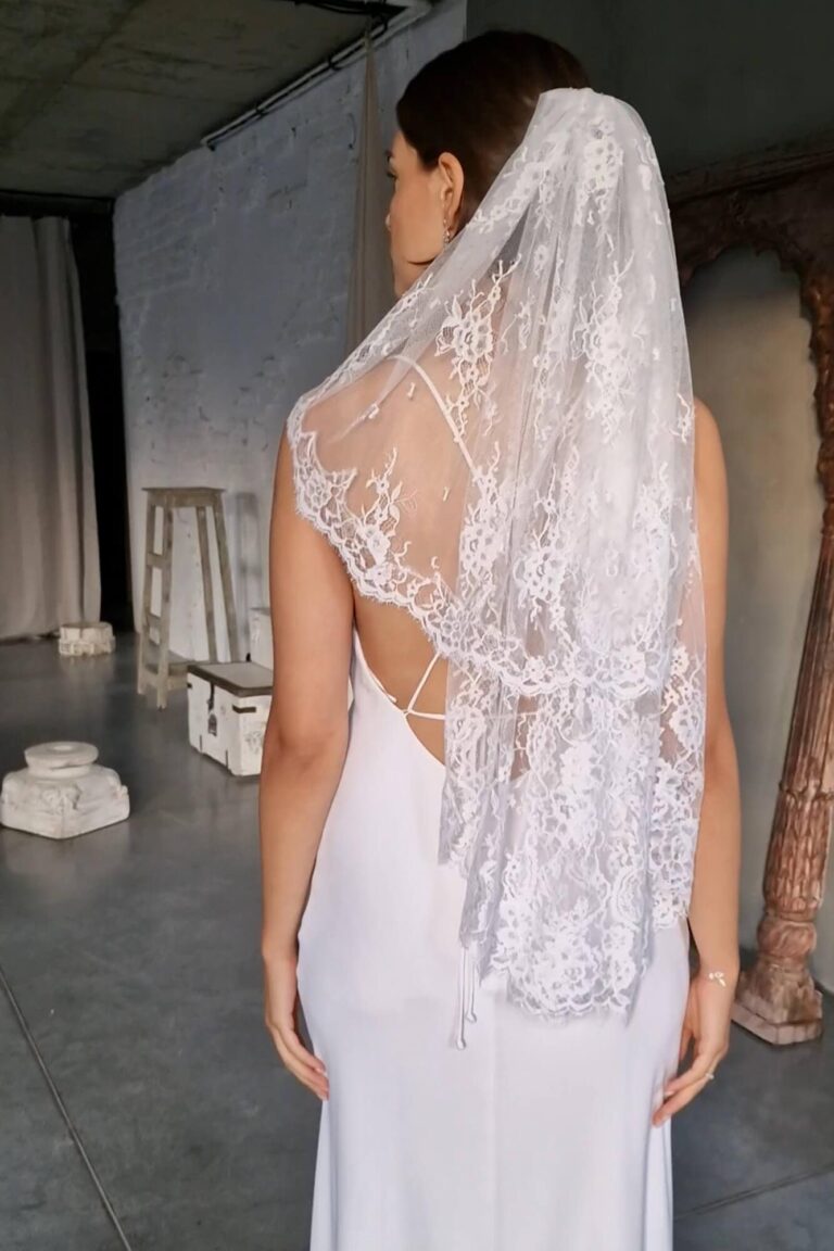 Suknia z odkrytymi plecami i długim koronkowym welonem widziana z tyłu.