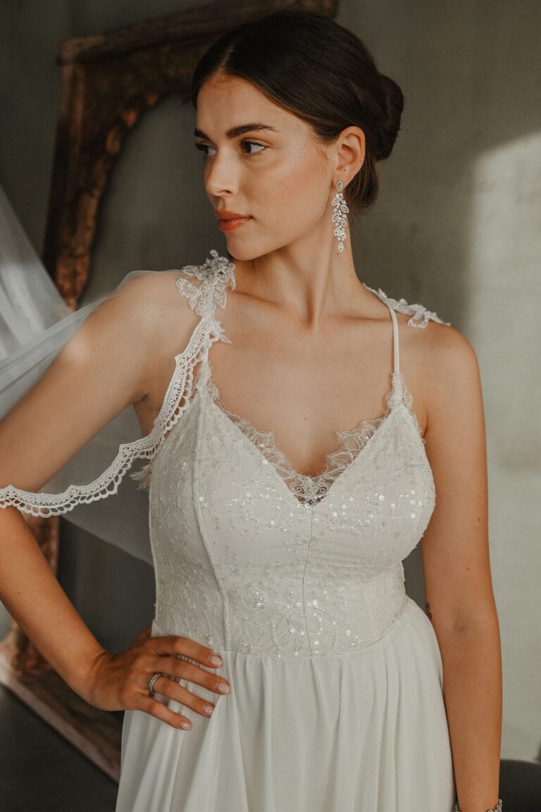 Suknia z koronkowymi ramiączkami i delikatnym dekoltem w kształcie litery V.