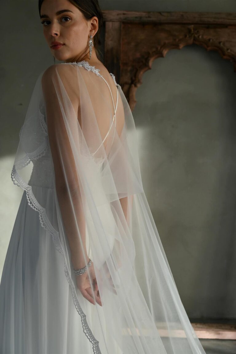 Suknia ślubna z odkrytymi plecami i długim tiulowym trenem.