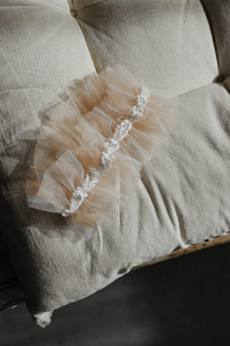 Suknia z tiulu z falbanami i koronkowym wykończeniem na poduszce.