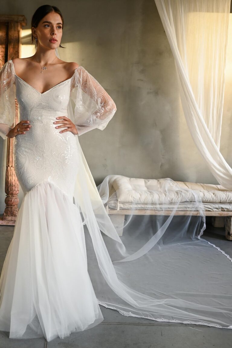 Suknia ślubna z długimi koronkowymi rękawami i trenem z tiulu.