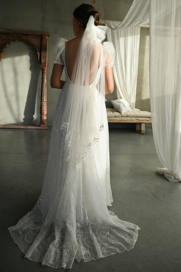 Suknia ślubna z odkrytymi plecami i długim tiulowym trenem.